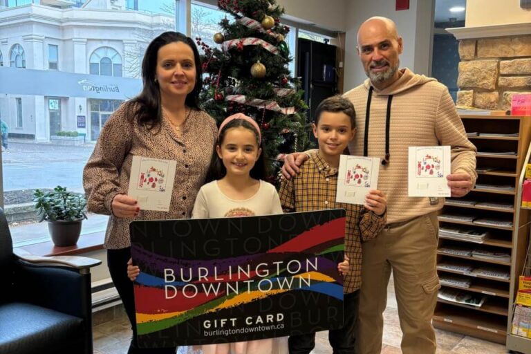 family holding large gift card during holiday season